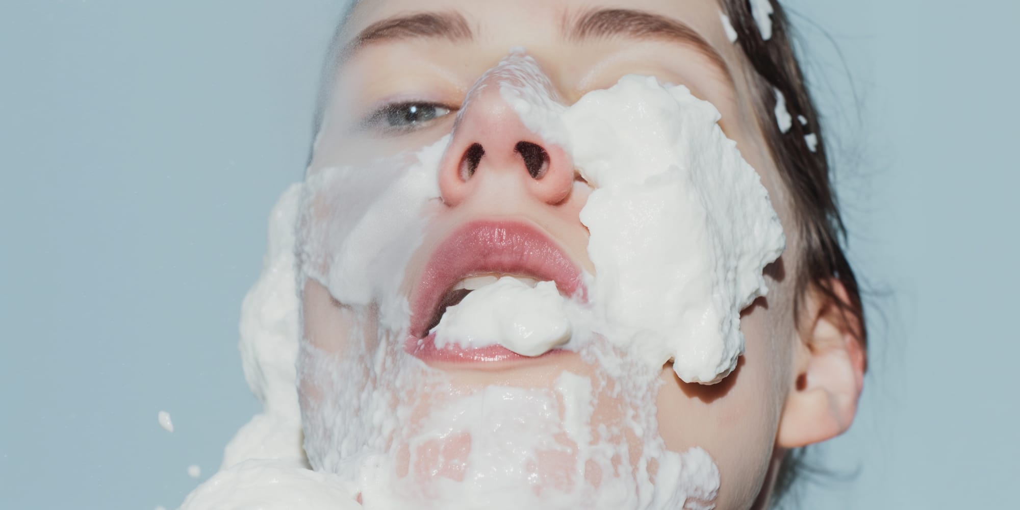 Sexy woman face covered in white cream