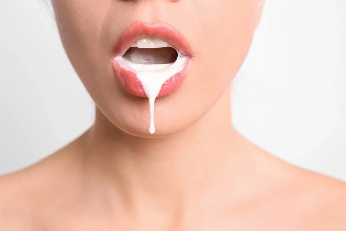 Close-up of a woman’s lips with white liquid dripping from her mouth (possible cum), symbolizing the moment secrets become impossible to hide.